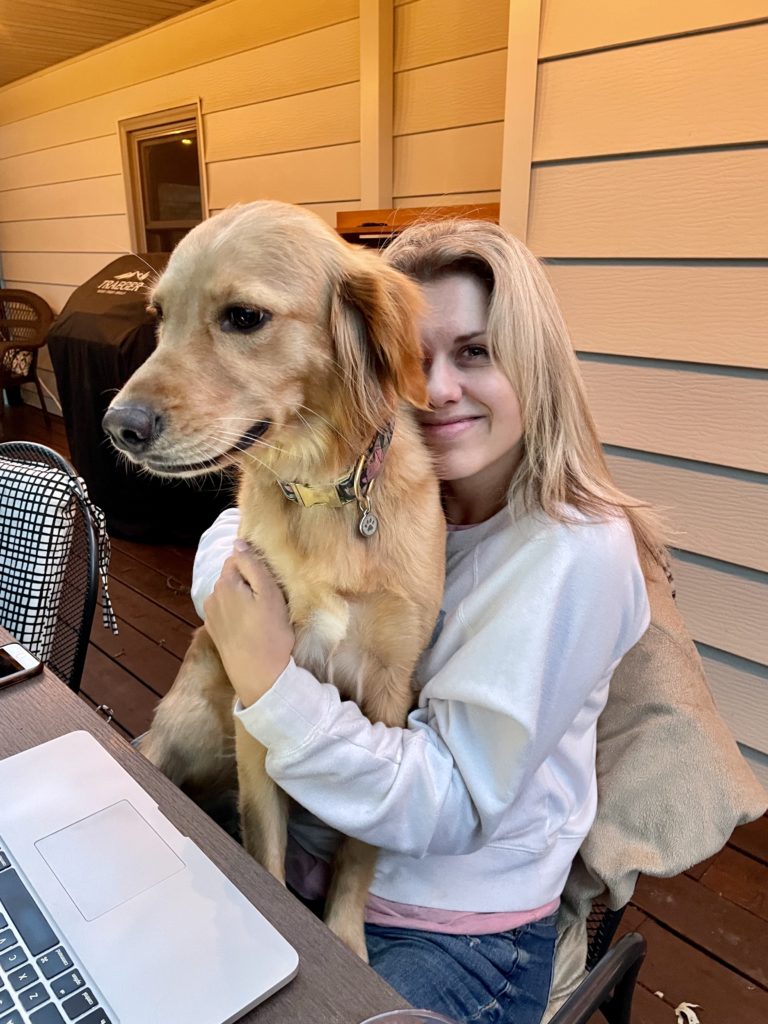 Sarah Klongerbo working on her deck with her dog Pali