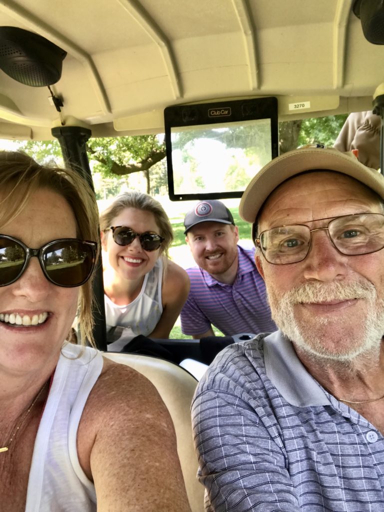 Troy and Sarah Klongerbo and his parents in a golf cart