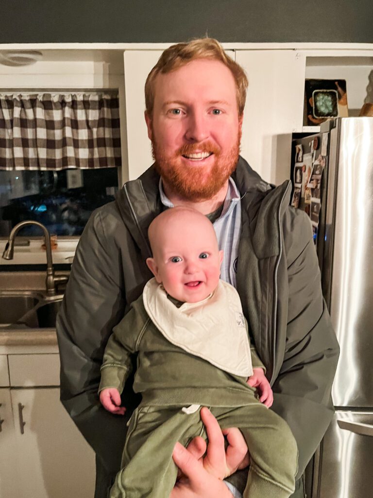 Troy Klongerbo holding his son Calvin in his kitchen